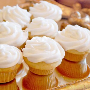 vanilla mini cupcakes with white icing on golden platter
