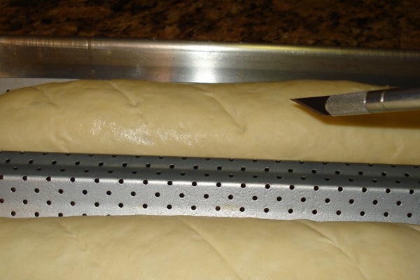 scoring baguette dough with exacto knife
