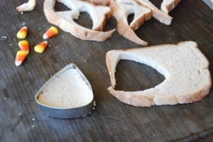 Cutting bread into shape of candy corn.