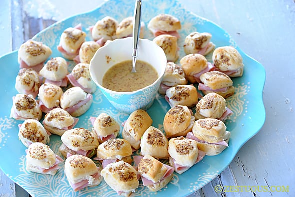 ham bites arranged on a platter with dipping sauce in the middle