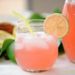 pink lemonade in a short glass with a lemon slice garnish and straw