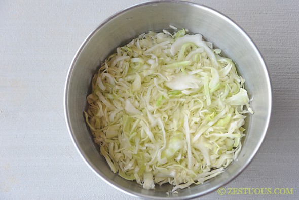 shredded cabbage sitting in a metal mixing bowl