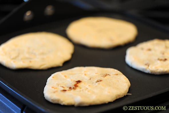 pupusas cooking on griddle
