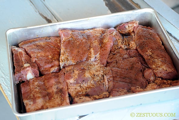 cut up ribs with seasoning in a pan