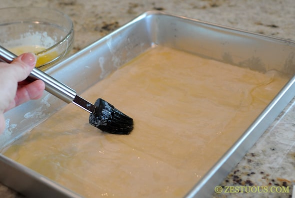 phyllo dough in a pan with butter brushed on it