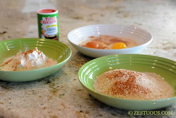 3 bowls, one with breadcrumbs, one with flour and spices, and one with eggs