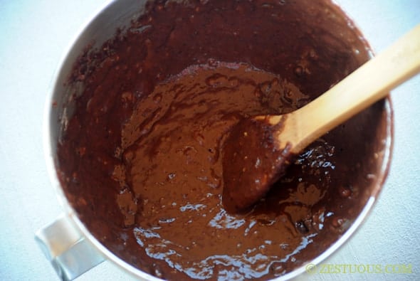 chocolate zucchini bread batter in a mixing bowl with wooden spoon