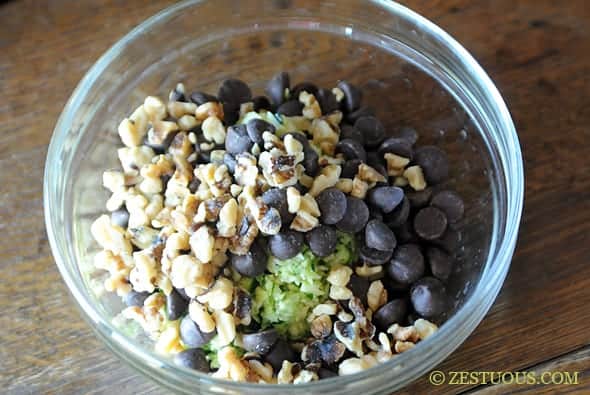 walnuts, shredded zucchini, and chocolate chips in a glass bowl