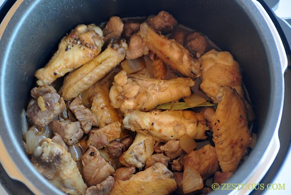 crockpot with chicken and pork added to it