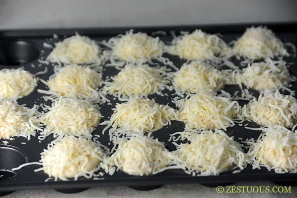 Cheesy Garlic Bites in muffin tin topped with cheese