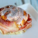 close up of bacon wrapped around baked cinnamon roll.