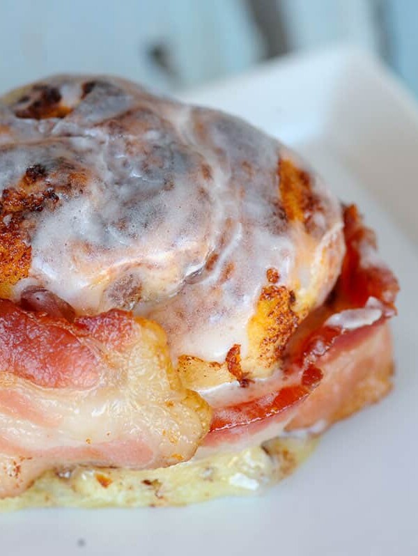 close up of bacon wrapped around baked cinnamon roll.