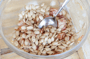 pumpkin seeds mixed in bowl with bacon.