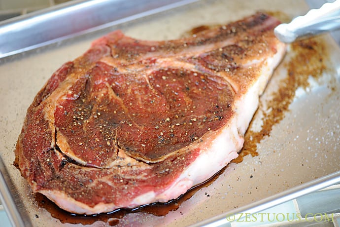 rib-eye steak marinating on sheet pan