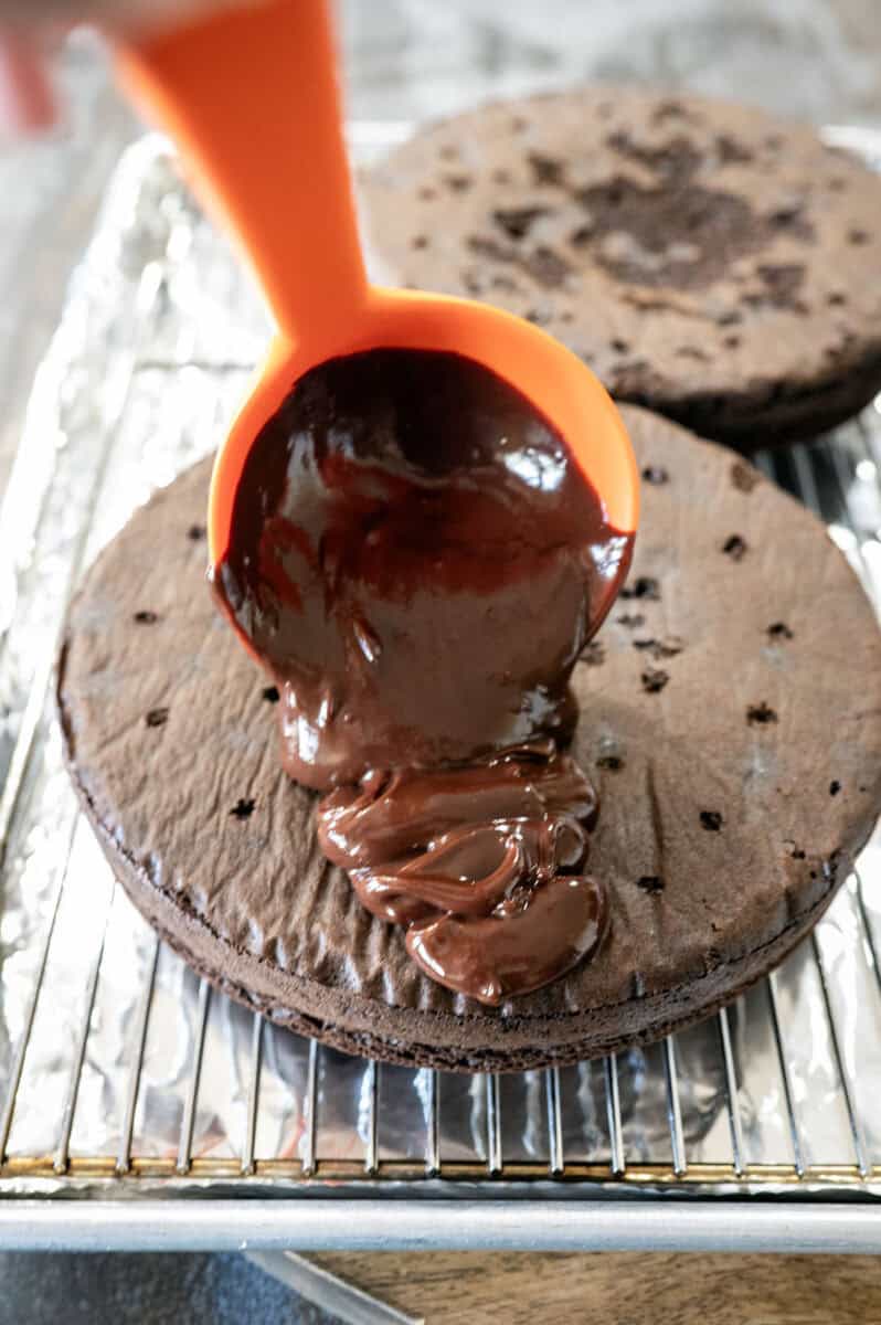 Pouring ganache on cake.